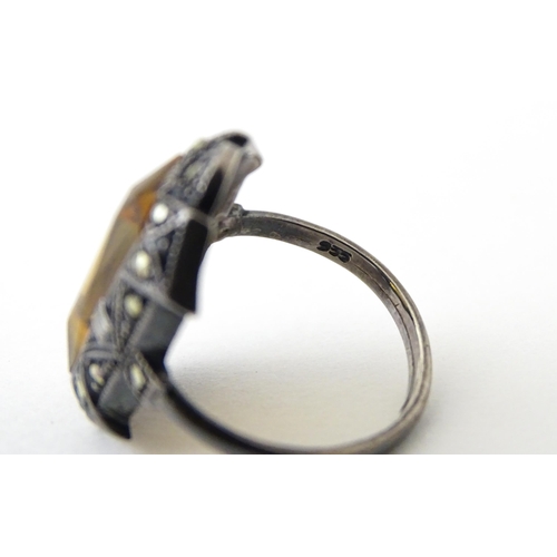 717 - A Continental silver ring set with central citrine bordered by marcasite. Ring size approx. I