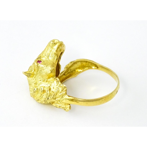 721 - A Continental gold ring with horse head decoration set with ruby stone eyes. Ring size approx. P