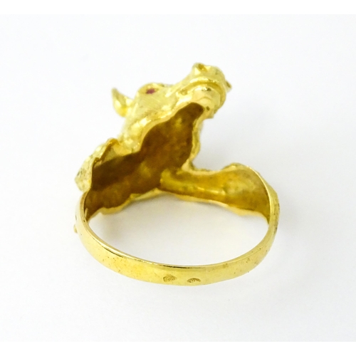 721 - A Continental gold ring with horse head decoration set with ruby stone eyes. Ring size approx. P