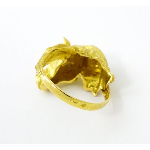 721 - A Continental gold ring with horse head decoration set with ruby stone eyes. Ring size approx. P