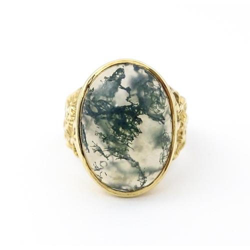 723 - A 9ct gold ring set with moss agate cabochon. Ring size approx. R 1/2