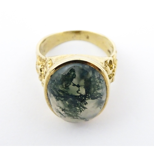 723 - A 9ct gold ring set with moss agate cabochon. Ring size approx. R 1/2