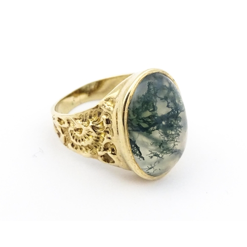 723 - A 9ct gold ring set with moss agate cabochon. Ring size approx. R 1/2