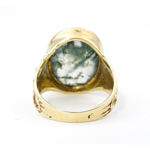 723 - A 9ct gold ring set with moss agate cabochon. Ring size approx. R 1/2