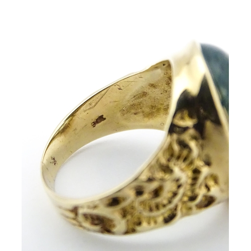 723 - A 9ct gold ring set with moss agate cabochon. Ring size approx. R 1/2