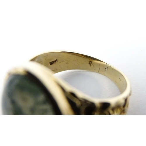 723 - A 9ct gold ring set with moss agate cabochon. Ring size approx. R 1/2