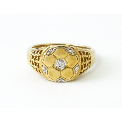 725 - A 9ct gold gentleman's ring with football decoration set with diamonds. Ring size approx. T