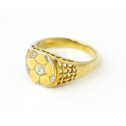 725 - A 9ct gold gentleman's ring with football decoration set with diamonds. Ring size approx. T