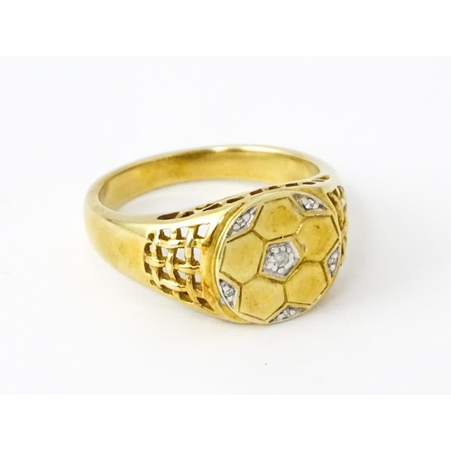 725 - A 9ct gold gentleman's ring with football decoration set with diamonds. Ring size approx. T