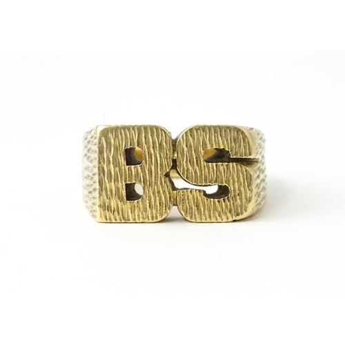 726 - A 9ct gold ring formed as the initials 'BS'. Ring size approx. N 1/2  (14g)