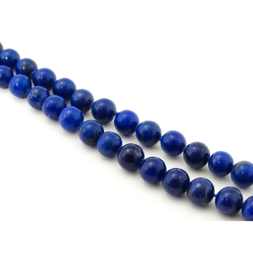 745 - A lapis lazuli bead necklace with drop detail, and silver gilt clasp. Approx. 23