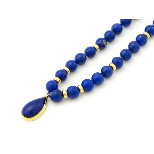 745 - A lapis lazuli bead necklace with drop detail, and silver gilt clasp. Approx. 23