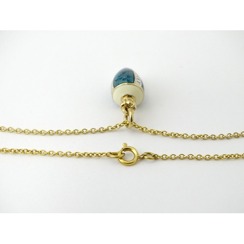 750 - A 9ct gold chain with a gilt metal pendant with enamel detail. Chain approx. 22