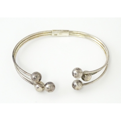 758 - Four silver / white bracelets of bangle form to include a Mexican example (4)