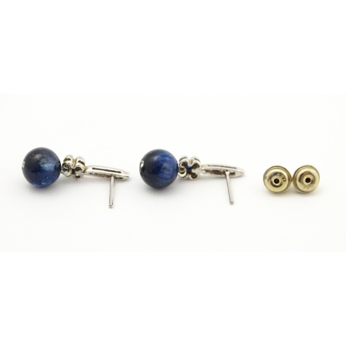 764 - A pair of white gold drop earrings set with diamonds, blue stone and bead detail. Approx. 3/4