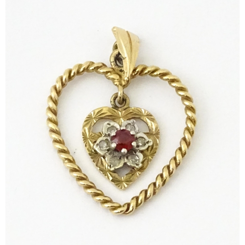 767 - A 9ct gold pendant of heart form with heart formed pendant to centre set with diamonds and red stone... 