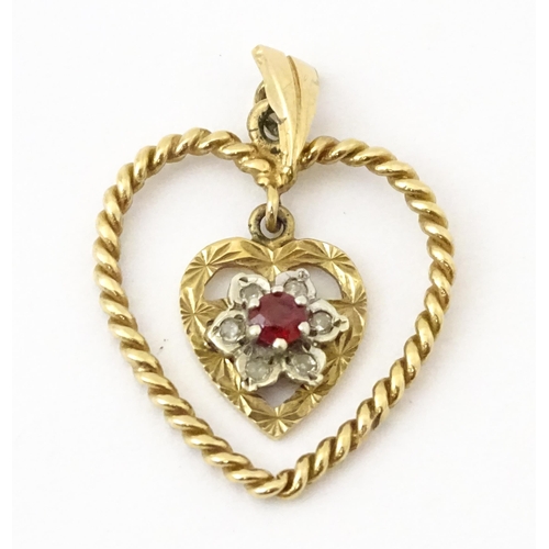 767 - A 9ct gold pendant of heart form with heart formed pendant to centre set with diamonds and red stone... 