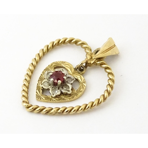 767 - A 9ct gold pendant of heart form with heart formed pendant to centre set with diamonds and red stone... 