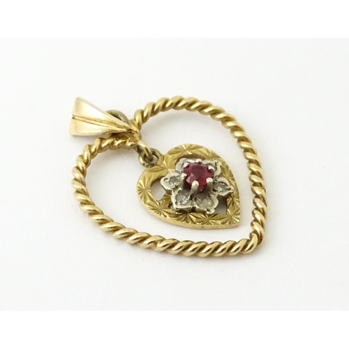 767 - A 9ct gold pendant of heart form with heart formed pendant to centre set with diamonds and red stone... 