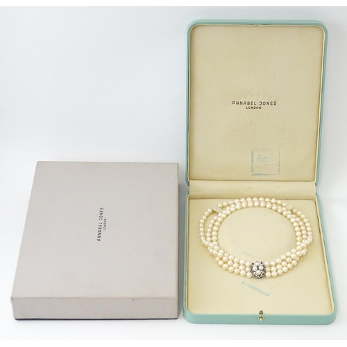 769 - A three strand pearl choker necklace with 14ct white gold clasp set with diamonds, sapphires, and pe... 