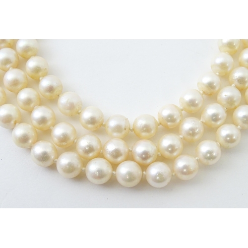 769 - A three strand pearl choker necklace with 14ct white gold clasp set with diamonds, sapphires, and pe... 