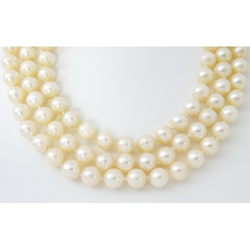 769 - A three strand pearl choker necklace with 14ct white gold clasp set with diamonds, sapphires, and pe... 