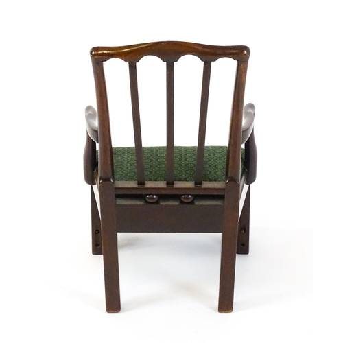 1500 - A late Georgian mahogany child's chair with swept arms and a foot rest. 17