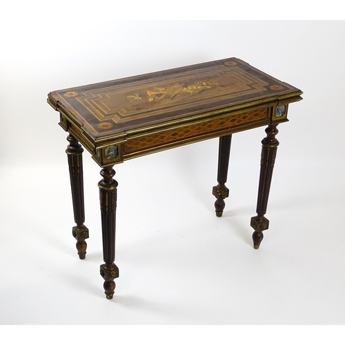 1513 - A 19thC card table with a marquetry inlaid cornucopia to the top and brass mouldings to the rim. The... 