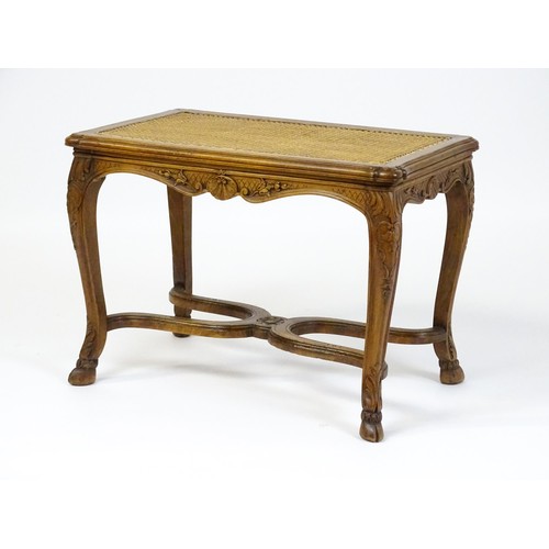 1541 - An early 20thC Louis XV style bergère stool with a caned top above four carved cabriole legs termina... 