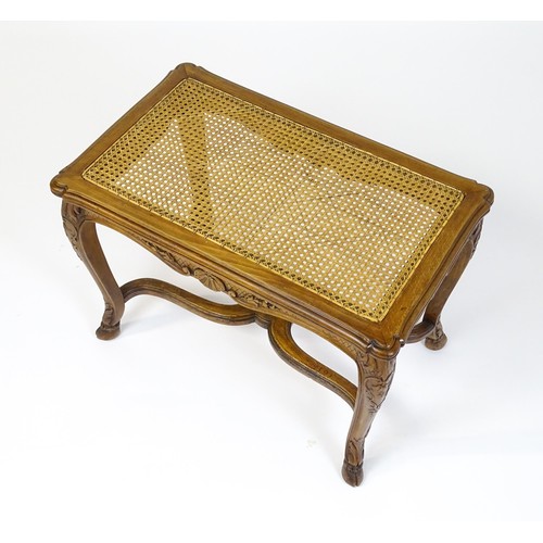 1541 - An early 20thC Louis XV style bergère stool with a caned top above four carved cabriole legs termina... 