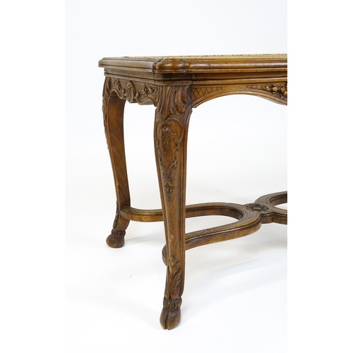 1541 - An early 20thC Louis XV style bergère stool with a caned top above four carved cabriole legs termina... 