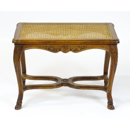 1541 - An early 20thC Louis XV style bergère stool with a caned top above four carved cabriole legs termina... 