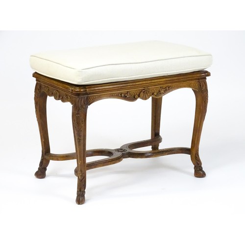 1541 - An early 20thC Louis XV style bergère stool with a caned top above four carved cabriole legs termina... 