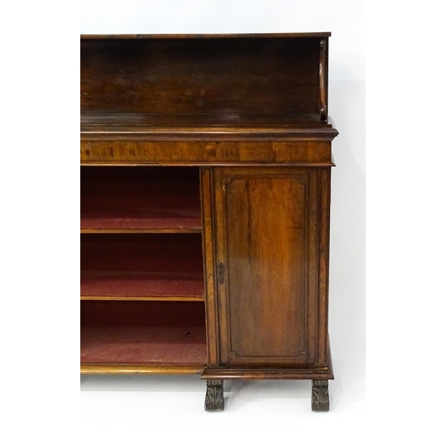 1597 - A 19thC rosewood bookcase with a moulded shelf raised on two scrolled brackets, the base having two ... 