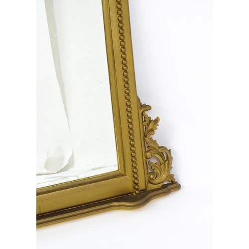 1598 - A modern mahogany mirror with a gilt finish, surmounted by a pierced, floral moulding and having mat... 