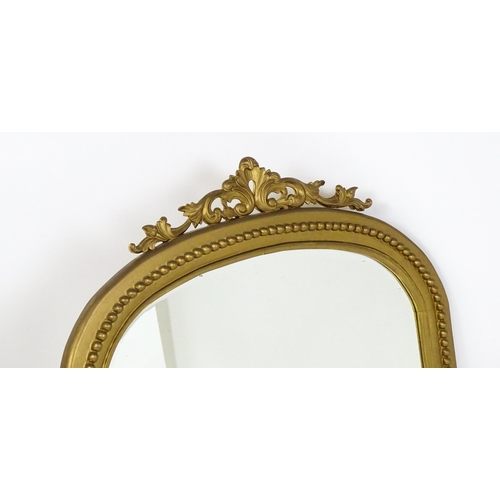 1598 - A modern mahogany mirror with a gilt finish, surmounted by a pierced, floral moulding and having mat... 