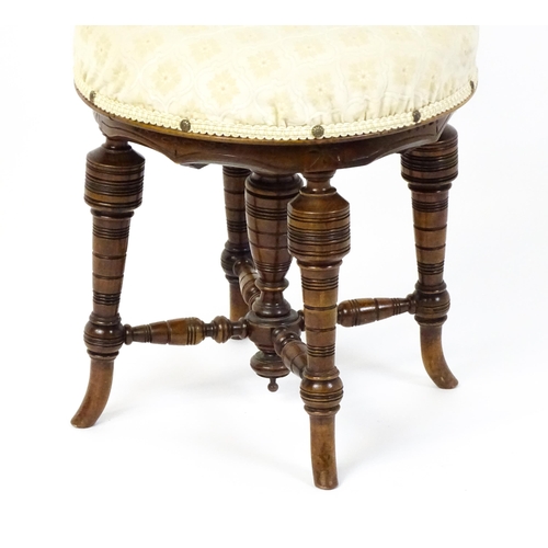 1599 - An Edwardian adjustable piano stool / chair with a floral carved top rail and turned finials to the ... 