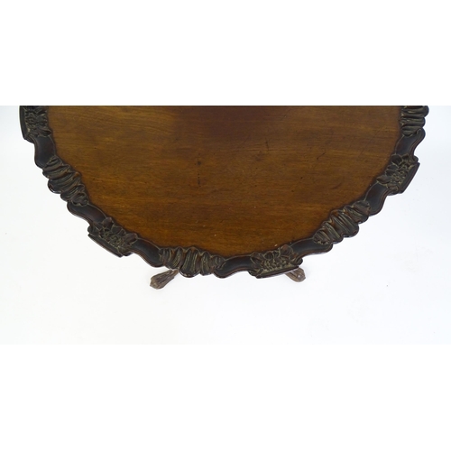 1618 - A mid 19thC mahogany tripod occasional table with a carved pie crust top and a birdcage movement. Th... 