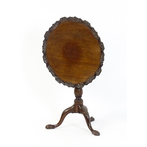 1618 - A mid 19thC mahogany tripod occasional table with a carved pie crust top and a birdcage movement. Th... 