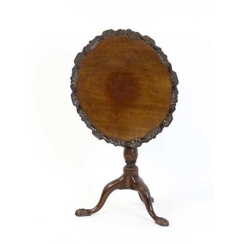 1618 - A mid 19thC mahogany tripod occasional table with a carved pie crust top and a birdcage movement. Th... 