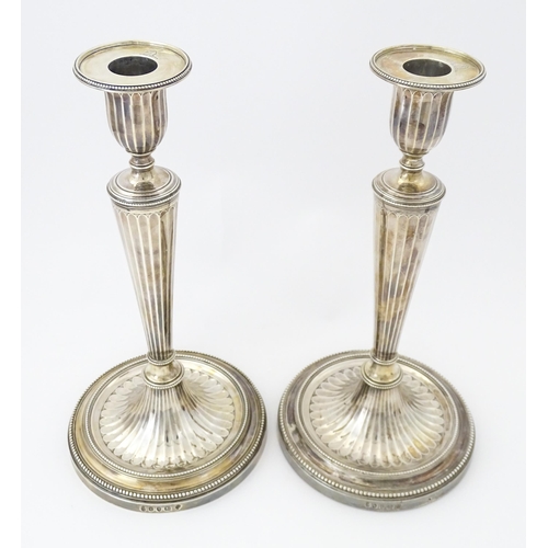 526 - A pair of George III Neo Classical silver candlesticks with engraved armorial detail, hallmarked Lon... 