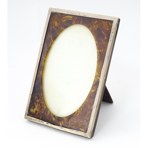 531 - An easel back photograph frame with tortoiseshell and silver surround, hallmarked Birmingham 1924, m... 