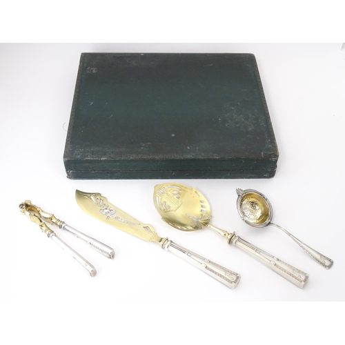 538 - A Chilean silver cased set comprising a strainer / sifter, server, nutcrackers, and knife, in the Ge... 