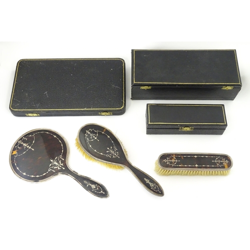 545 - Three individually cased silver dressing table items comprising two brushes and a hand mirror with t... 