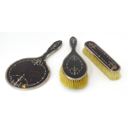 545 - Three individually cased silver dressing table items comprising two brushes and a hand mirror with t... 