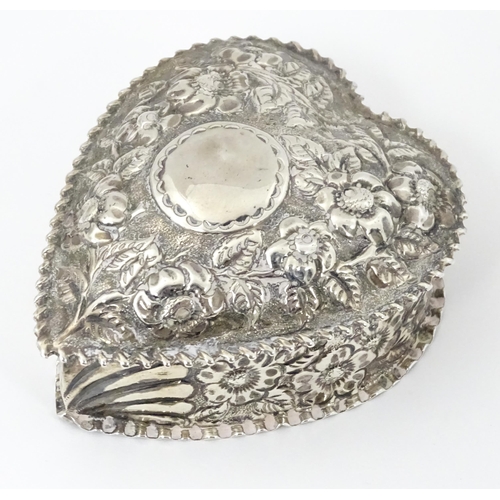 266 - A Victorian silver box of heart form with embossed floral decoration, the lid hinging open to reveal... 