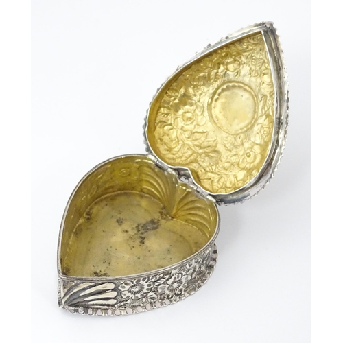 266 - A Victorian silver box of heart form with embossed floral decoration, the lid hinging open to reveal... 