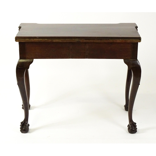 1449 - An Irish Chippendale mahogany card table with a carved inverted breakfront top, opening to show a ba... 