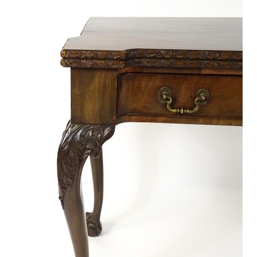 1449 - An Irish Chippendale mahogany card table with a carved inverted breakfront top, opening to show a ba... 