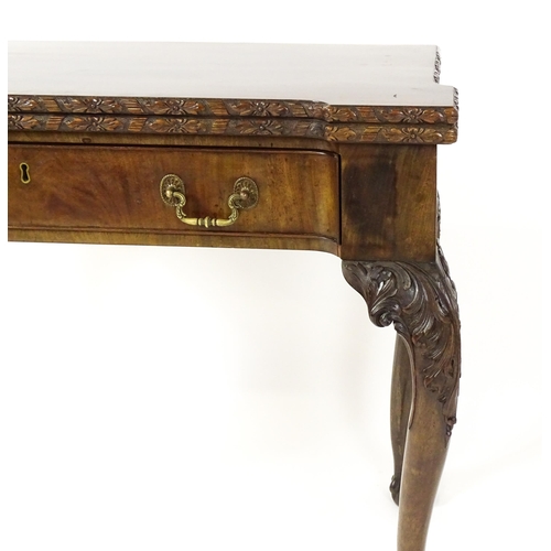 1449 - An Irish Chippendale mahogany card table with a carved inverted breakfront top, opening to show a ba... 